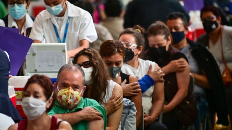 Personas esperan después de recibir dosis de la vacuna Pfizer-BioNTech contra el COVID-19 en un centro de vacunación para personas mayores de 50 años instalado en la Biblioteca Vasconcelos, en la Ciudad de México (México) el 11 de mayo de 2021. (Pedro Pardo/AFP vía Getty Images)
