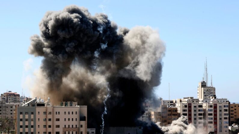 Una espesa columna de humo se eleva desde la Torre Jala al ser destruida en un ataque aéreo israelí en la ciudad de Gaza controlada por Hamás, el 15 de mayo de 2021.(MAHMUD HAMS/AFP a través de Getty Images)