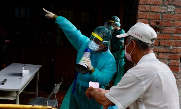 Un residente local escucha al personal médico antes de hacer cola para las pruebas del virus COVID-19 en el distrito de Wanhua en Taipei, Taiwán, el 19 de mayo de 2021. (SAM YEH/AFP vía Getty Images)