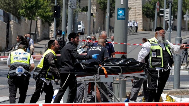 Los servicios de emergencia israelíes transportan el cuerpo de un asaltante, que fue abatido por la policía tras apuñalar a dos hombres israelíes, en una estación de tranvía cerca del barrio de Sheikh Jarrah, en el este de Jerusalén anexionado por Israel, el 24 de mayo de 2021. (Ahmad Gharabli / AFP vía Getty Images)