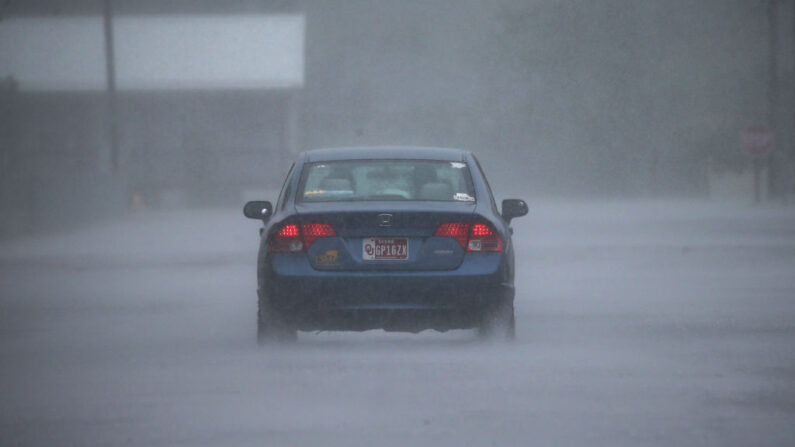 Un coche conduce a través de fuertes lluvias e inundaciones en las calles durante el huracán Delta el 9 de octubre de 2020 en Lake Arthur, Louisiana (EE.UU.). (Mario Tama/Getty Images)