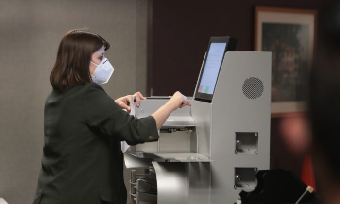 Una foto de archivo muestra a un votante electoral recopilando el escrutinio de una máquina de votación, en una foto de archivo de las elecciones del 3 de noviembre. (Foto de Scott Olson/Getty Images)