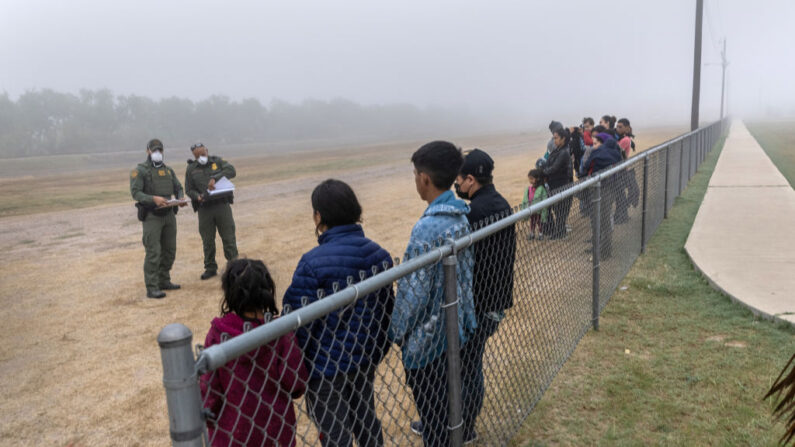 Menores no acompañados (izq.), se agrupan separados de las familias que esperan ser procesados por los agentes de la Patrulla Fronteriza de Estados Unidos cerca de la frontera entre Estados Unidos y México el 10 de abril de 2021 en La Joya, Texas. (John Moore/Getty Images)
