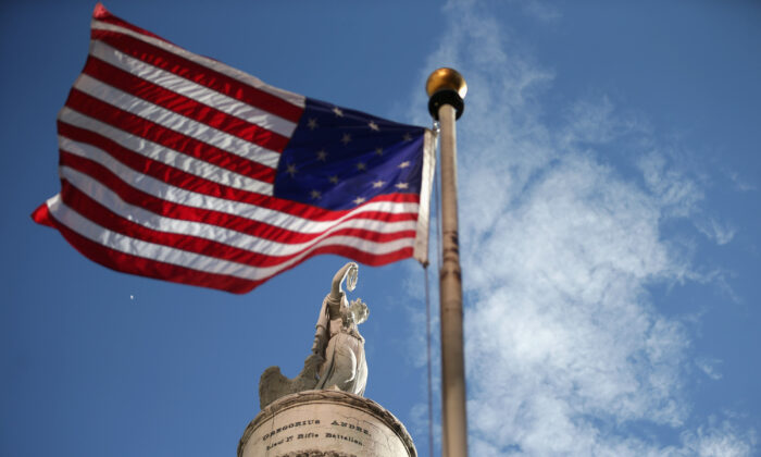 La bandera de Estados Unidos con 15 franjas y 15 estrellas, como la que se ondeó en Fort McHenry durante la Guerra de 1812, enmarca el Monumento a la Batalla en Baltimore, Maryland, el 12 de septiembre de 2014. (Chip Somodevilla/Getty Images)