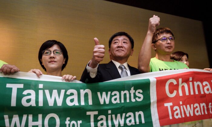 El ministro de Salud de Taiwán, Chen Shih-chung (C), posa junto a manifestantes después de una conferencia de prensa al margen de la Asamblea anual de la Organización Mundial de la Salud en Ginebra, Suiza, el 21 de mayo de 2018. (Fabrice Coffrini /AFP vía Getty Images)