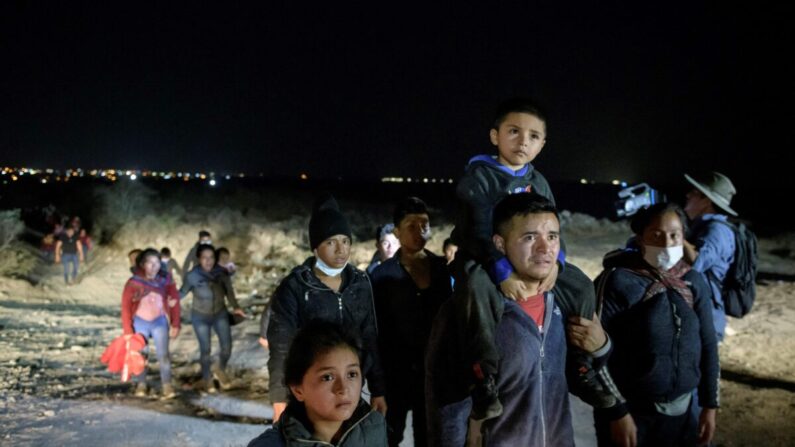 Un grupo de inmigrantes que llegó ilegalmente por el río Grande desde México se dirige por una vía hacia un puesto de control de procesamiento establecido por agentes de la Patrulla Fronteriza en la ciudad de Roma (Texas) el 27 de marzo de 2021. (Ed Jones/AFP vía Getty Images)
