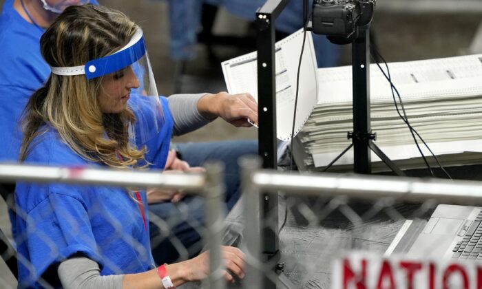 Trabajadores examinan las papeletas de votos emitidas en el condado de Maricopa en las elecciones de 2020 durante una auditoría en el Veterans Memorial Coliseum de Phoenix, Arizona, el 6 de mayo de 2021. (Matt York/AP Photo)