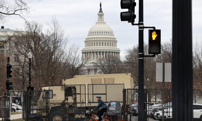 Una valla de seguridad de 8 pies de altura cubierta con alambre de púas de espiral rodea el Capitolio de los EE. UU. y  los vehículos de la Guardia Nacional se encuentran estacionados dentro del perímetro temporal en Washington, el 16 de marzo de 2021. (Chip Somodevilla/Getty Images)