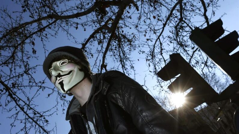 "En rechazo a los asesinatos y hostigamientos" de la fuerza pública durante las protestas, el colectivo de "hackers" Anonymous se atribuyó el ataque a la página web del Ejército de Colombia. En la imagen el registro de un hombre con una máscara que identifica a Anonymous. EFE/Javier Lizon/Archivo