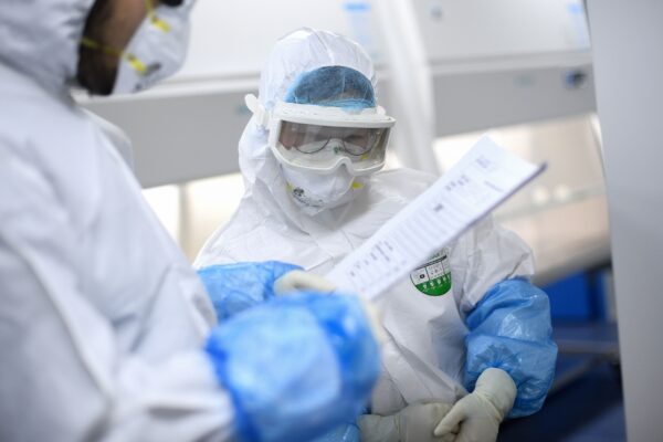 Técnicos de laboratorio trabajan en muestras que se analizarán para detectar COVID-19, en un laboratorio de BGI, en Wuhan, China, el 6 de febrero de 2020. (STR/AFP a través de Getty Images)