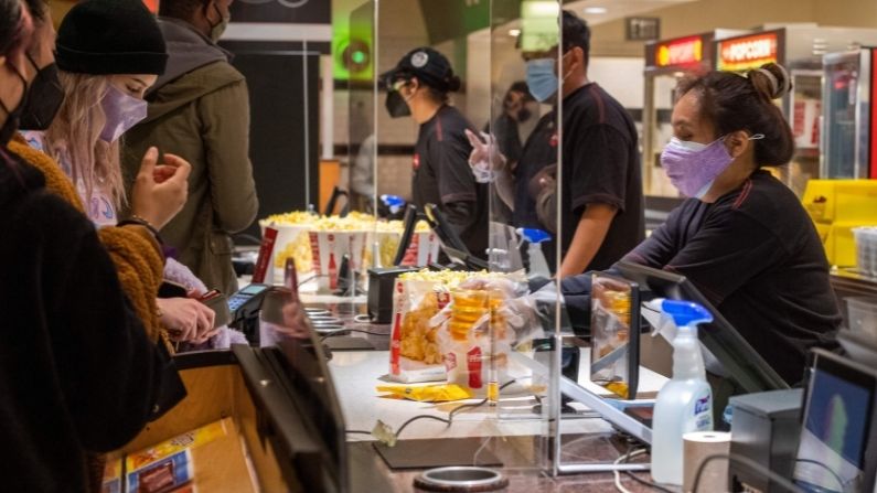 Los espectadores compran palomitas y bebidas en el puesto de concesión del teatro AMC Burbank el día de la reapertura en Burbank, California, el 15 de marzo de 2021. (VALERIE MACON/AFP vía Getty Images)
