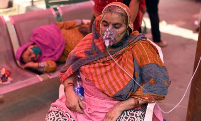 Un paciente respira con la ayuda de oxígeno proporcionado por un gurdwara, un lugar de culto para los sijs, bajo una tienda de campaña instalada al borde de la carretera en medio de la pandemia COVID-19 en Ghaziabad, India, el 26 de abril de 2021. (Sajjad Hussain/Getty Images)