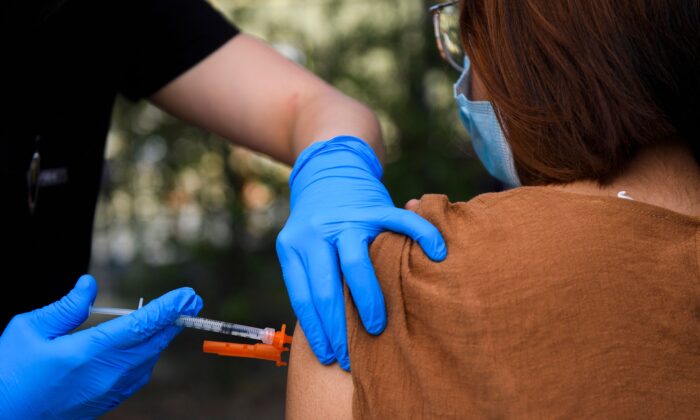 Una chica de 15 años recibe una vacuna contra la COVID-19 en una clínica de vacunación móvil en el centro Weingart East Los Angeles YMCA en Los Ángeles, California, el 14 de mayo de 2021. (Patrick T. Fallon/AFP a través de Getty Images)