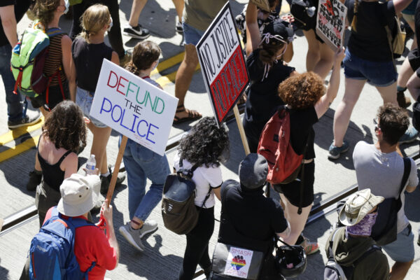 Gente con carteles durante una marcha de "Defund the Police" desde la cárcel juvenil del condado de King hasta el ayuntamiento en Seattle, Washington, el 5 de agosto de 2020. (Jason Redmond/AFP a través de Getty Images)
