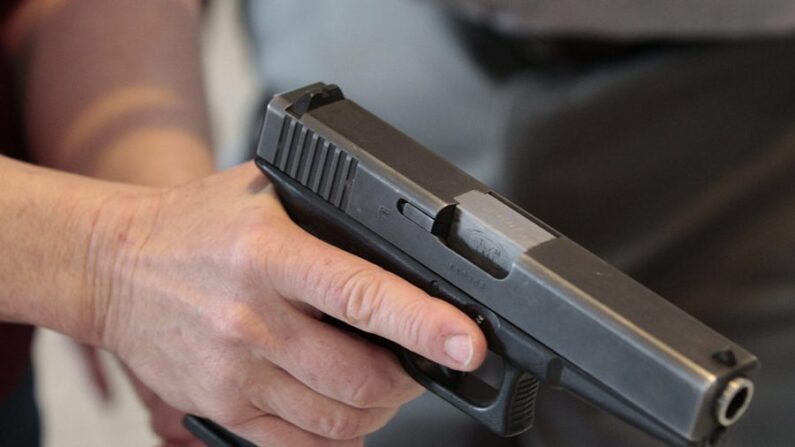 Una persona sostiene una pistola en una foto de archivo. (George Frey/Getty Images)
