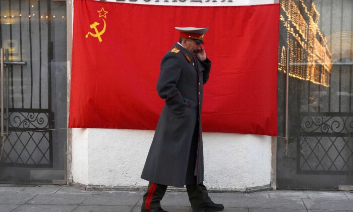 Un personificador del líder soviético Joseph Stalin pasa por delante de una bandera roja con el martillo y la hoz en el centro de Moscú el 21 de noviembre de 2016. (Vasily Maximov/AFP vía Getty Images)