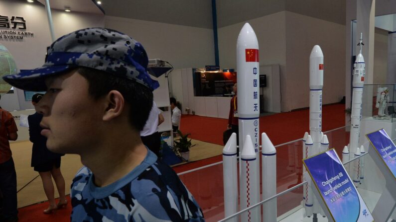 Un guardia de seguridad junto a modelos de cohetes chinos expuestos en Beijing el 24 de septiembre de 2013. El régimen chino está probando armas que pronto podrían poner en peligro los satélites en todas las órbitas. (Mark Ralston/AFP/Getty Images)