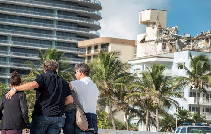 Personas observan el edificio de 12 pisos que colapsó parcialmente en Surfside, Florida, EE.UU., este 26 de 2021. (EFE/EPA/CRISTOBAL HERRERA-ULASHKEVICH)