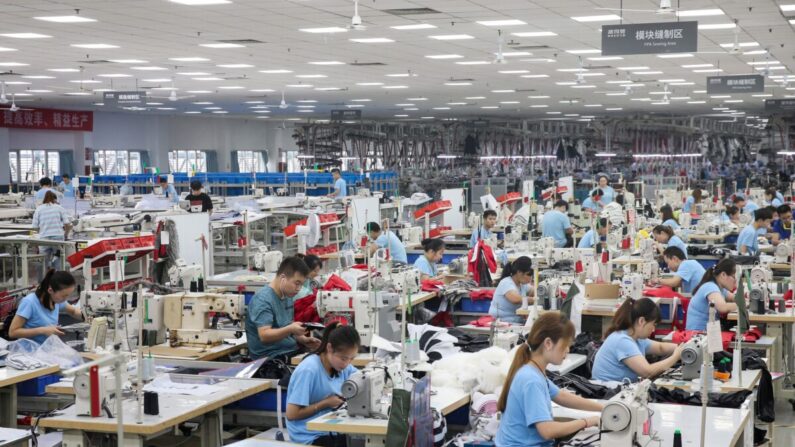 Los empleados producen abrigos de plumón en una fábrica de la empresa china de ropa Bosideng en Nantong, en la provincia oriental china de Jiangsu, el 24 de septiembre de 2019. (STR/AFP vía Getty Images)