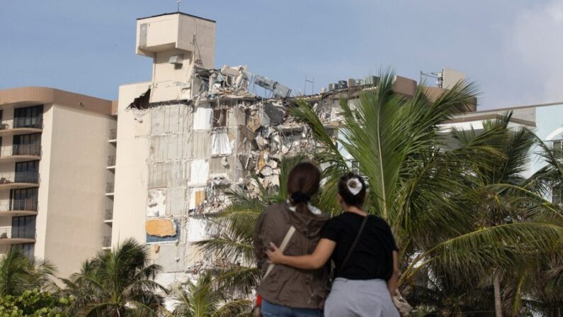  María Fernanda Martínez (izq.) y Mariana Cordeiro (der.) miran mientras las operaciones de búsqueda y rescate continúan en el sitio del edificio de condominios Champlain Towers South parcialmente colapsado en Surfside, Florida, el 25 de junio de 2021. (Joe Raedle/Getty Images) 