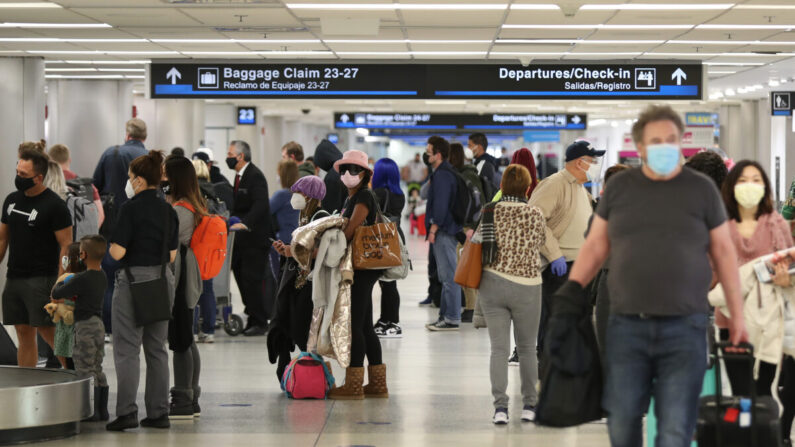 Las personas recogen su equipaje después de llegar al Aeropuerto Internacional de Miami en un avión desde Nueva York en Miami, Florida, el 1 de febrero de 2021. (Joe Raedle/Getty Images)