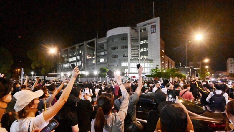 Los partidarios del periódico de Hong Kong Apple Daily agitan las luces de sus celulares frente a la sede del periódico en Hong Kong el 23 de junio de 2021. (Sung Pi-lung/The Epoch Times)