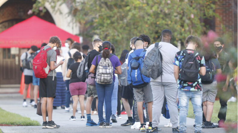 Estudiantes de secundaria esperan en la fila para que se les revise la temperatura antes de entrar al campus en una foto de archivo. (Octavio Jones/Getty Images)