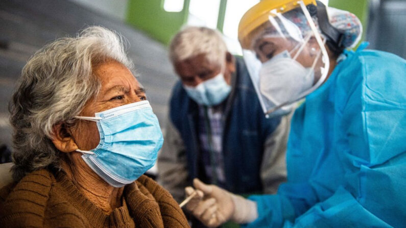 Una trabajadora sanitaria inocula una dosis de la vacuna de Pfizer-BioNTech contra el COVID-19 a una persona mayor, en un centro de vacunación en Lima (Perú) el 23 de abril de 2021. (Ernesto Benavides/AFP vía Getty Images)