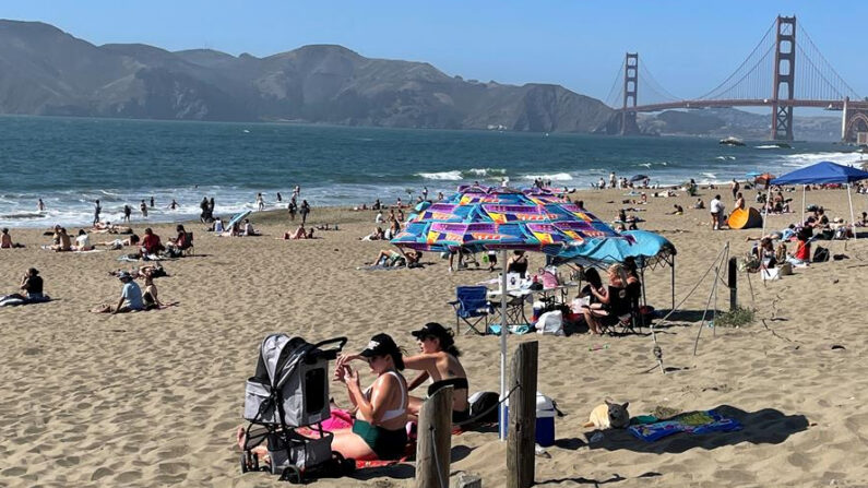 Varias personas disfrutan de un día de sol el 17 de junio de 2021, frente al puente Golden Gate, en la playa Baker de San Francisco, California (EE.UU.). EFE/ Marc Arcas