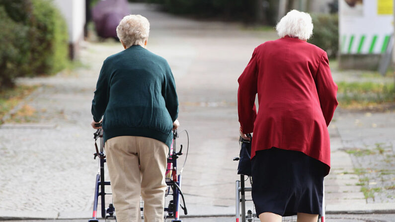 En una foto ilustrativa, dos ancianas empujan carros de la compra por una calle. (Sean Gallup/Getty Images)