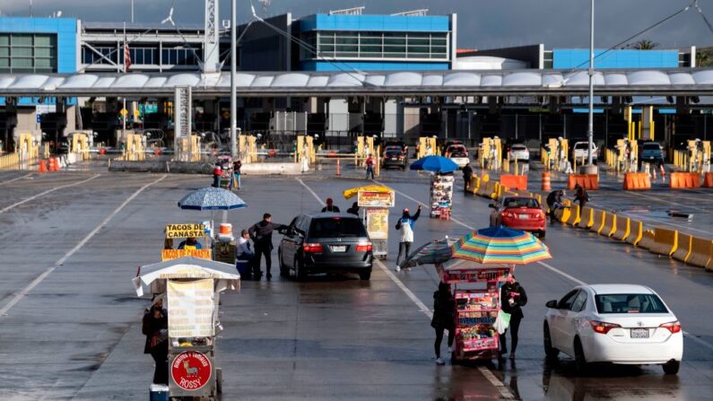 Vendedores esperan a los coches que cruzan a los Estados Unidos en el puerto de entrada de San Ysidro, en Tijuana, estado de Baja California, México, el 18 de abril de 2020. (Guillermo Arias / AFP vía Getty Images)