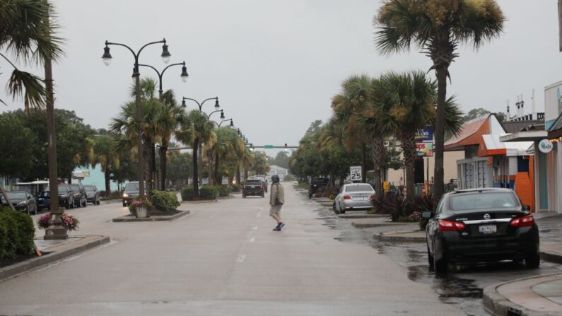 Un hombre cruza la calle en el centro de North Myrtle Beach mientras la tormenta tropical Isaias se acerca a la costa de Carolina del Sur el 3 de agosto de 2020. (Logan Cyrus/AFP vía Getty Images)