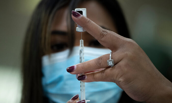 Una farmaceuta se prepara para inyectar la vacuna Pfizer anti-COVID, en Falls Church, Virginia, el 30 de diciembre de 2020. (Brendan Smialowski/AFP a través de Getty Images)