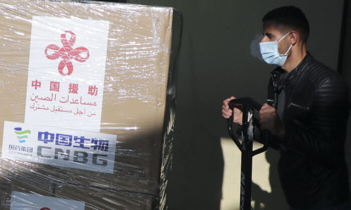 Un trabajador palestino descarga un cargamento de vacunas de Sinopharm donadas por Beijing en la ciudad cisjordana de Naplusa el 29 de marzo de 2021. (Jaafar Ashtiyeh/AFP vía Getty Images)