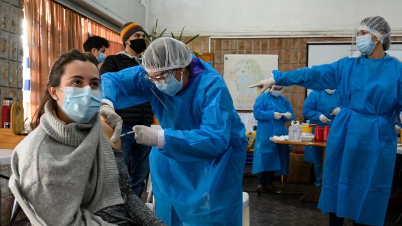 Una mujer es inoculada con la primera dosis de la vacuna contra covid-19 de Pfizer-BioNTech en Paso de Carrasco, departamento de Canelones, Uruguay, el 26 de mayo de 2021. (Eitan Abramovich/AFP vía Getty Images)