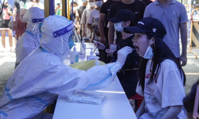 Una mujer (dcha.) se somete a una prueba de ácido nucleico en Guangzhou (China) el 30 de mayo de 2021. (AFP vía Getty Images)