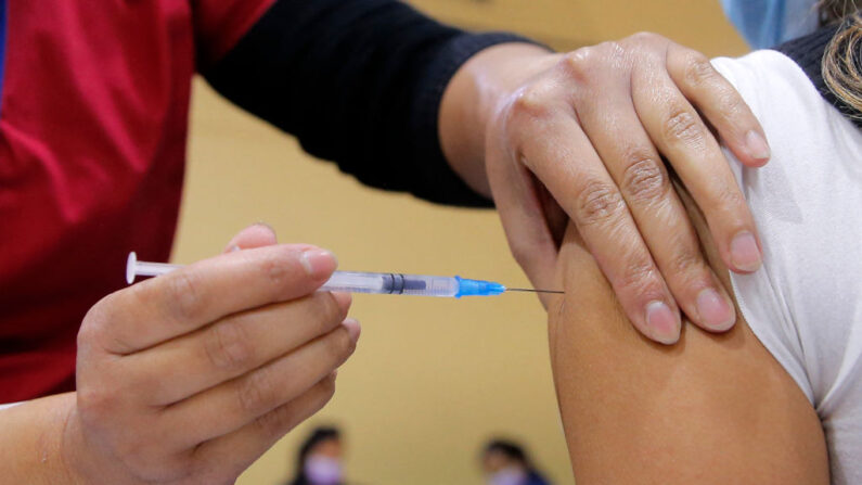 Una enfermera inocula a una mujer una dosis de vacuna contra el COVID-19 en Santiago (Chile) el 3 de junio de 2021. (Javier Torres/AFP vía Getty Images)