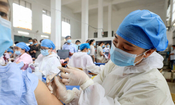 El 3 de junio de 2021, un trabajador sanitario administra la vacuna Sinovac contra Covid-19 a un residente de Rongan, en la región de Guangxi, al sur de China. (STR/AFP vía Getty Images)