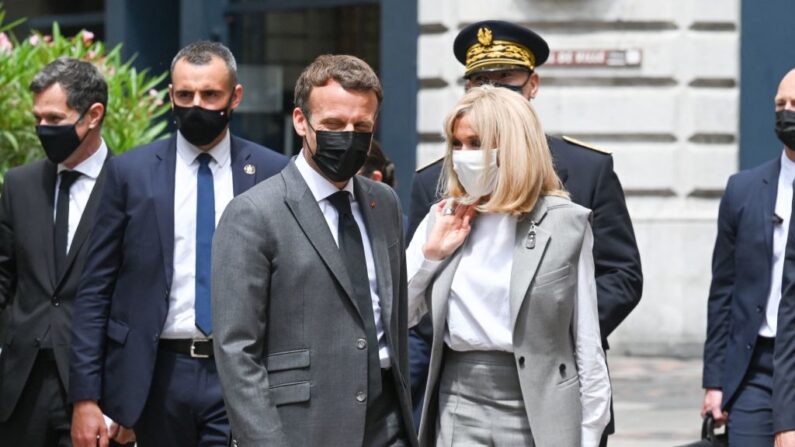 El presidente francés Emmanuel Macron (c) camina junto a su esposa Brigitte Macron antes de un almuerzo en Valence, el 8 de junio de 2021, durante una visita de un día en el departamento de Drome, en el sureste de Francia, la segunda etapa de una gira a nivel nacional antes de las elecciones presidenciales del próximo año. (Philippe Desmazes/POOL/AFP vía Getty Images)