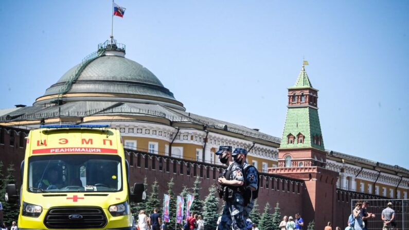 Militares de la Guardia Nacional Rusa (Rosgvardia) con mascarillas caminan por la Plaza Roja frente a una ambulancia en el centro de Moscú, Rusia, el 18 de junio de 2021, en medio de la crisis relacionada con la pandemia de covid-19. (Alexander Nemenov/AFP vía Getty Images)