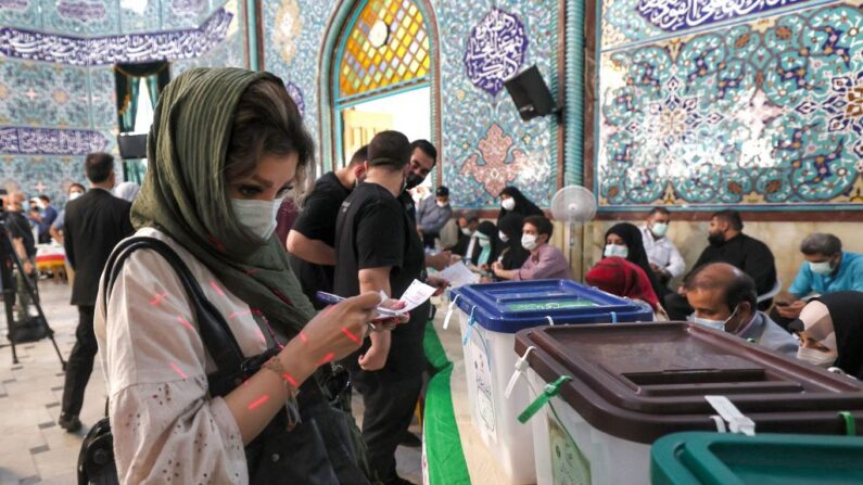 Una mujer examina una papeleta antes de depositarla en un colegio electoral en Teherán, la capital de Irán, el 18 de junio de 2021, durante las elecciones presidenciales de 2021. (Atta Kenare/AFP vía Getty Images)