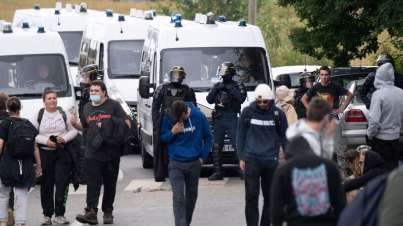 Agentes de policía evacuan a los asistentes a una fiesta ilegal en un campo de Redon, en el noroeste de Francia, el 19 de junio de 2021. (Loic Venance/AFP vía Getty Images)