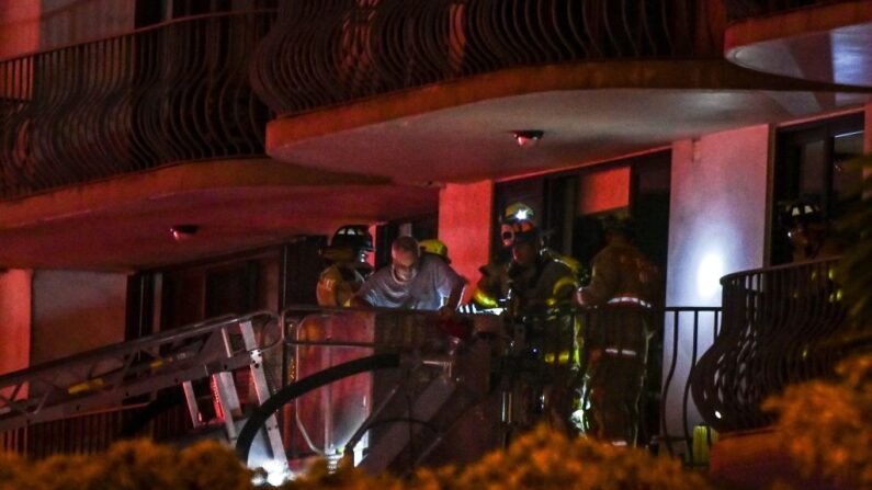 Trabajadores de los bomberos rescatan a un residente en un edificio parcialmente derrumbado en Miami Beach, Florida, el 24 de junio de 2021. (Chandan Khanna/AFP vía Getty Images)