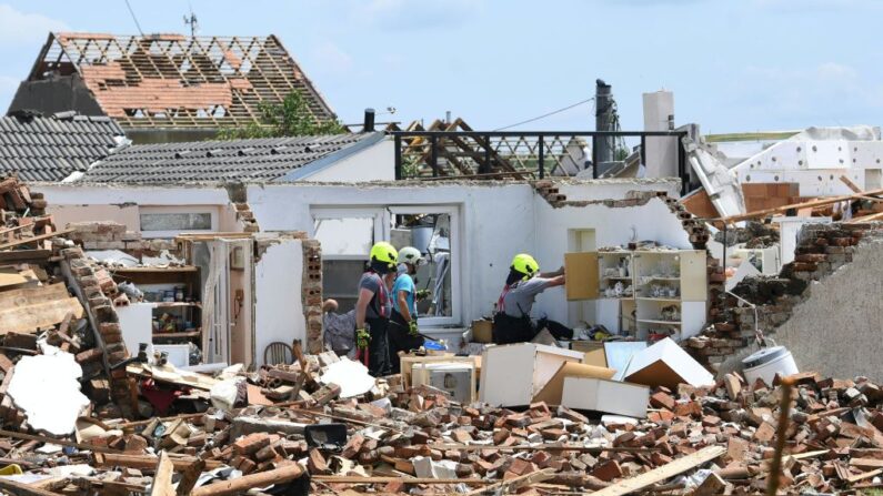 Un grupo de personas busca objetos en edificios gravemente dañados el 25 de junio de 2021 en el pueblo de Mikulcice, a 60 km al sur de Brno, en Moravia del Sur (República Checa), después de haber sido azotado por un tornado. (Helmut Fohringer/APA/AFP vía Getty Images)
