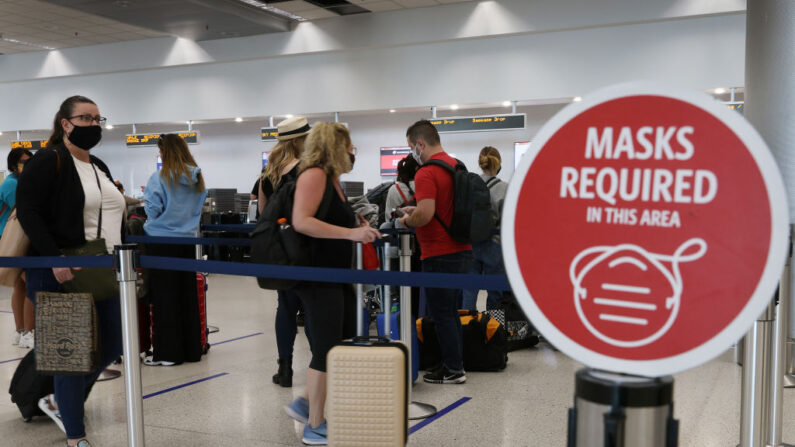 Un letrero que dice "se requieren máscarillas en esta área" se ve mientras los viajeros se preparan para el check-in de un vuelo de Delta airlines en el Aeropuerto Internacional de Miami el 1 de febrero de 2021 en Miami, Florida. Una orden ejecutiva firmada por el presidente de EE.UU., Joe Biden, obliga a llevar máscarillas en las propiedades federales y en el transporte público. (Foto de Joe Raedle/Getty Images)