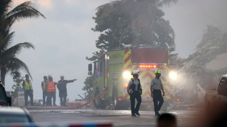 El personal del Cuerpo de Bomberos de Miami-Dade trabaja alrededor del edificio de condominios Champlain Towers South, que se derrumbó parcialmente, mientras continúan las operaciones de búsqueda y rescate el 25 de junio de 2021 en Surfside, Florida. (Joe Raedle/Getty Images)