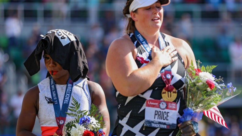 Gwendolyn Berry (izq.), tercer lugar, ignora la bandera de EE.UU. durante el Himno Nacional mientras DeAnna Price, primer lugar, también se encuentra en el podio después de la final de lanzamiento de martillo femenino, en el día nueve de las pruebas para los juegos olímpicos de Tokio, el 26 de junio de 2021, en Eugene, Oregon. (Patrick Smith/Getty Images)