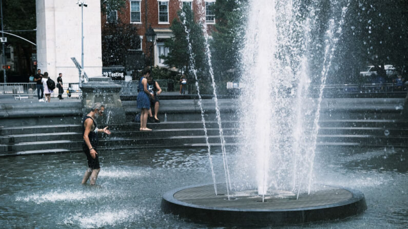 La gente se refresca en una fuente pública en el parque de Washington Square el 30 de junio de 2021 en la ciudad de Nueva York (EE.UU.). (Spencer Platt/Getty Images)