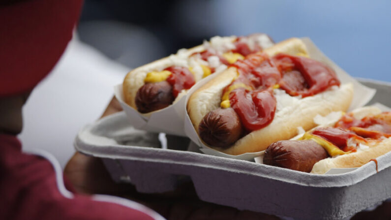 Un aficionado toma asiento con una bandeja de perros calientes durante la victoria por 4-0 de los Washington Nationals sobre los Philadelphia Phillies en el Nationals Park de Washington, D.C., el 3 de agosto de 2014. (Foto de Jonathan Ernst/Getty Images)