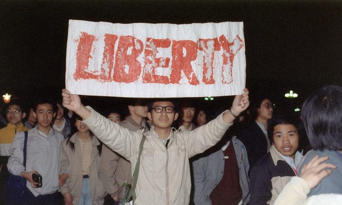 Un estudiante muestra una pancarta con uno de los lemas coreados por una multitud cercana a las 200,000 personas que llegó a la Plaza de Tiananmen, en Beijing, el 22 de abril de 1989. (Catherine Henriette/AFP/Getty Images)